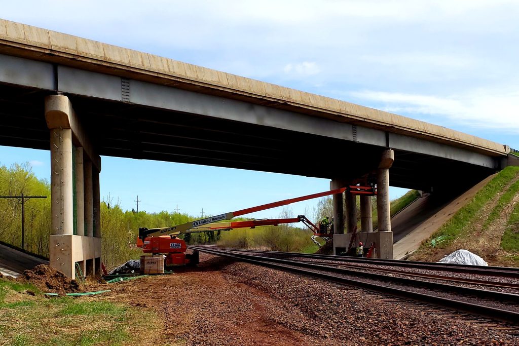 Highway overpass above an active rail line during bridge and trackside work