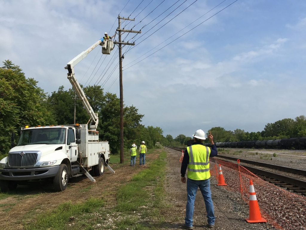 ROWC flagger protecting overhead power line work near active track